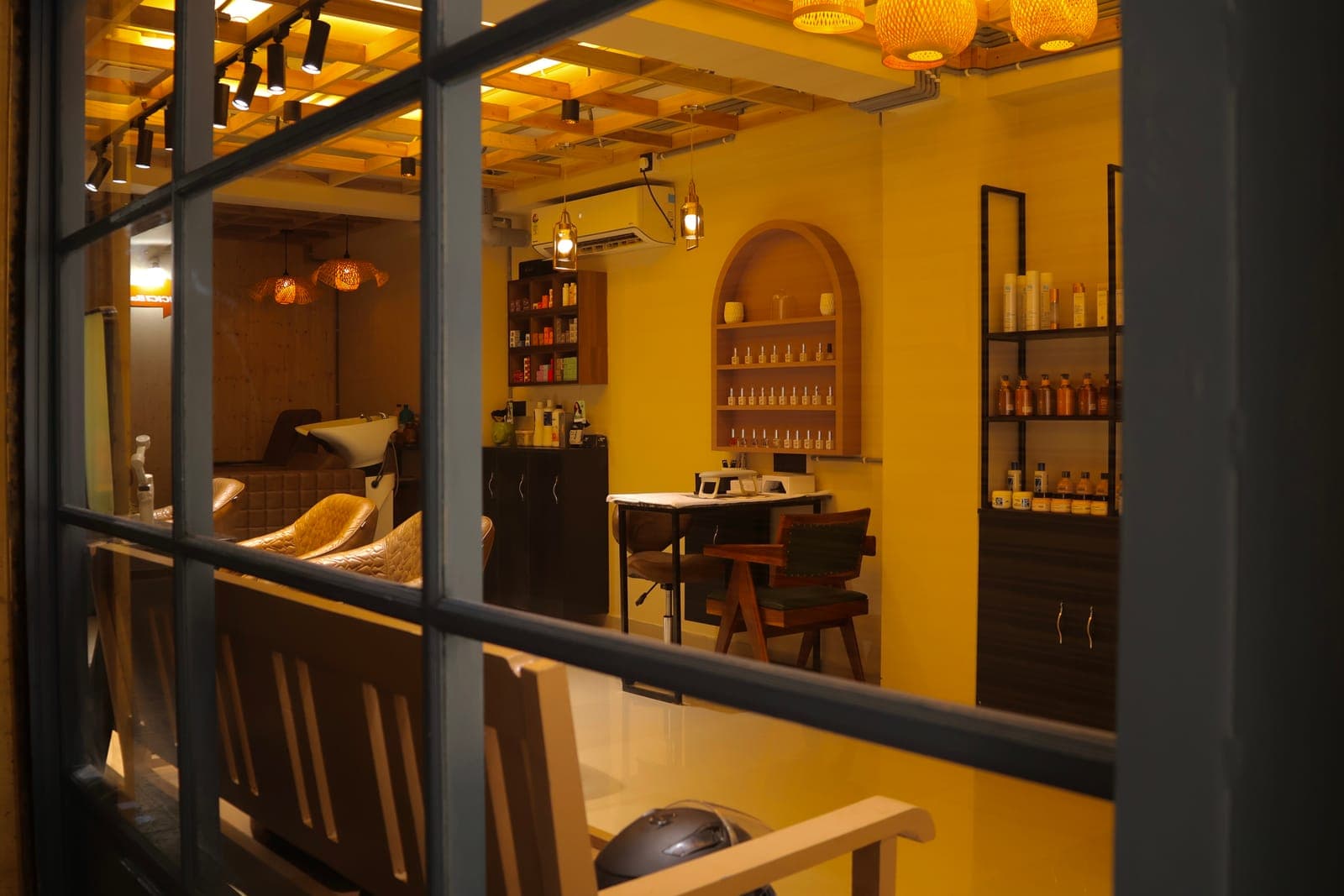 Hair Official seen from the street through its shopfront window, warmly lit in the evening